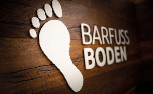 Schauraum mit Barfuss Boden Logo
