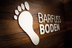 Schauraum mit Barfuss Boden Logo